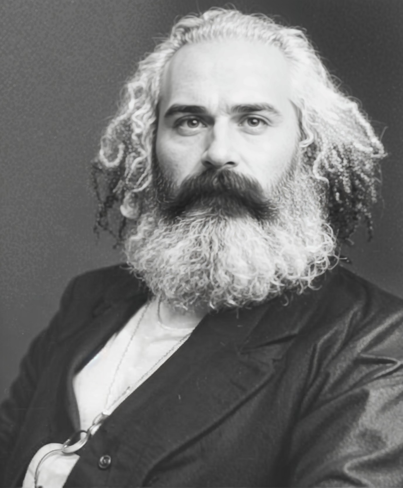 Distinguished man with gray hair and beard in dark jacket
