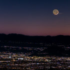 Aerial Nighttime Cityscape with Crescent Moon and Mountains