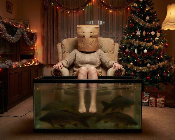 Person in Armchair with Paper Bag and Aquarium Setting