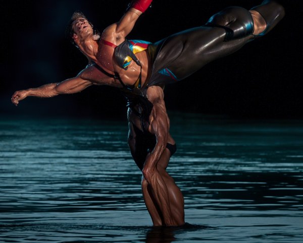 Male Acrobats Performing Dramatic Lift Above Water