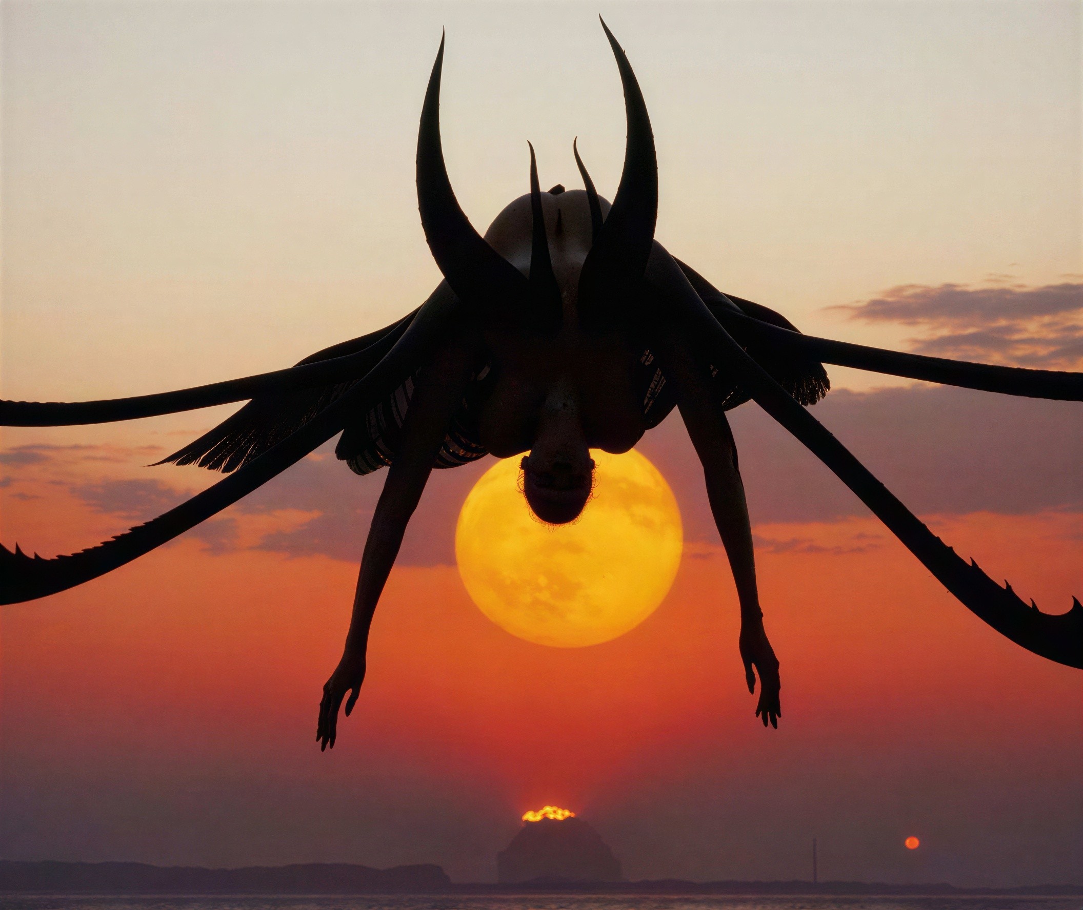 Silhouette of Insectoid Figure Against Sunset and Moon
