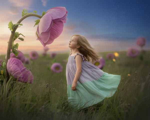Young girl in pastel dress among vibrant flowers
