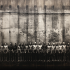 Black-and-white photo of individuals against industrial backdrop