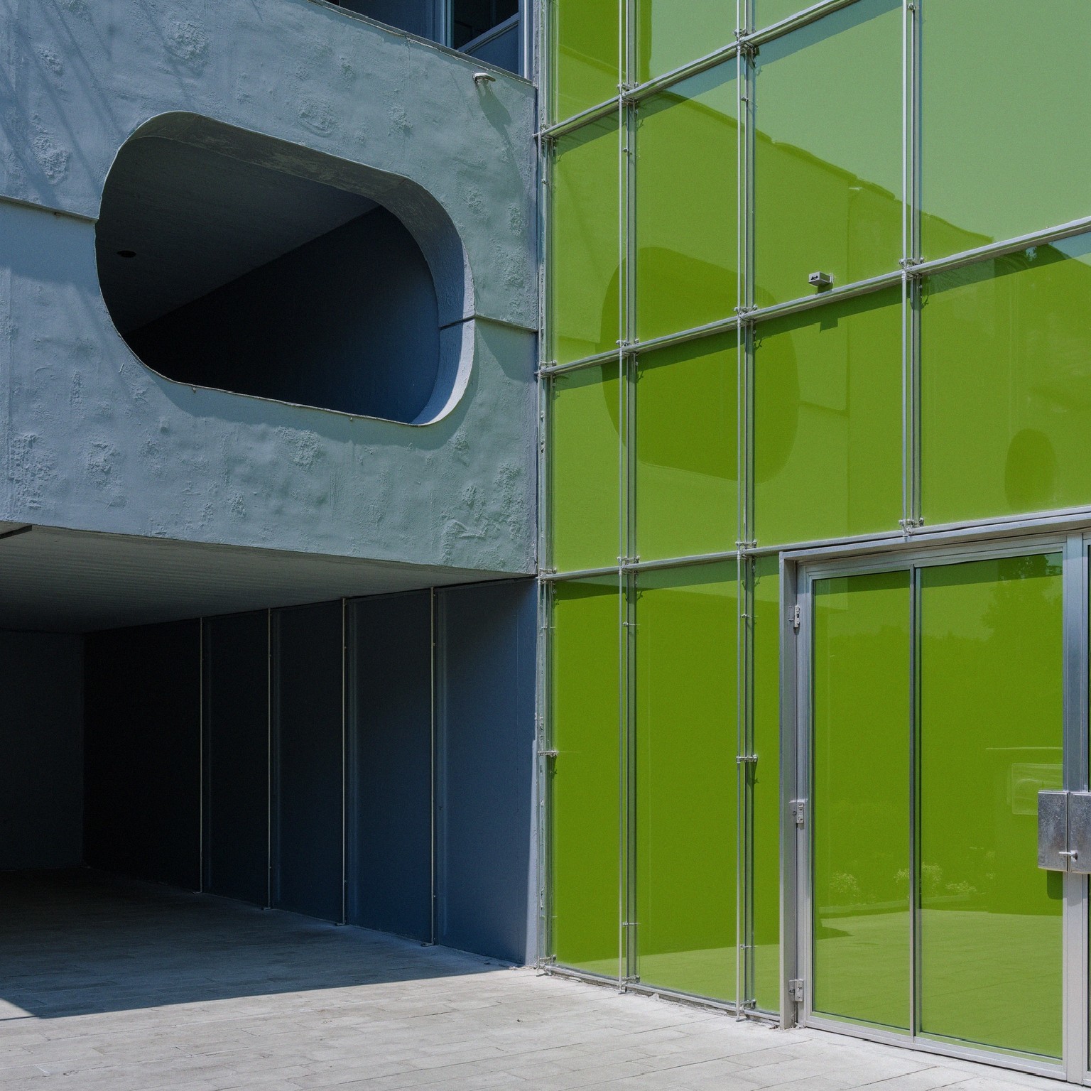 Modern Building with Gray Concrete and Green Glass Panels
