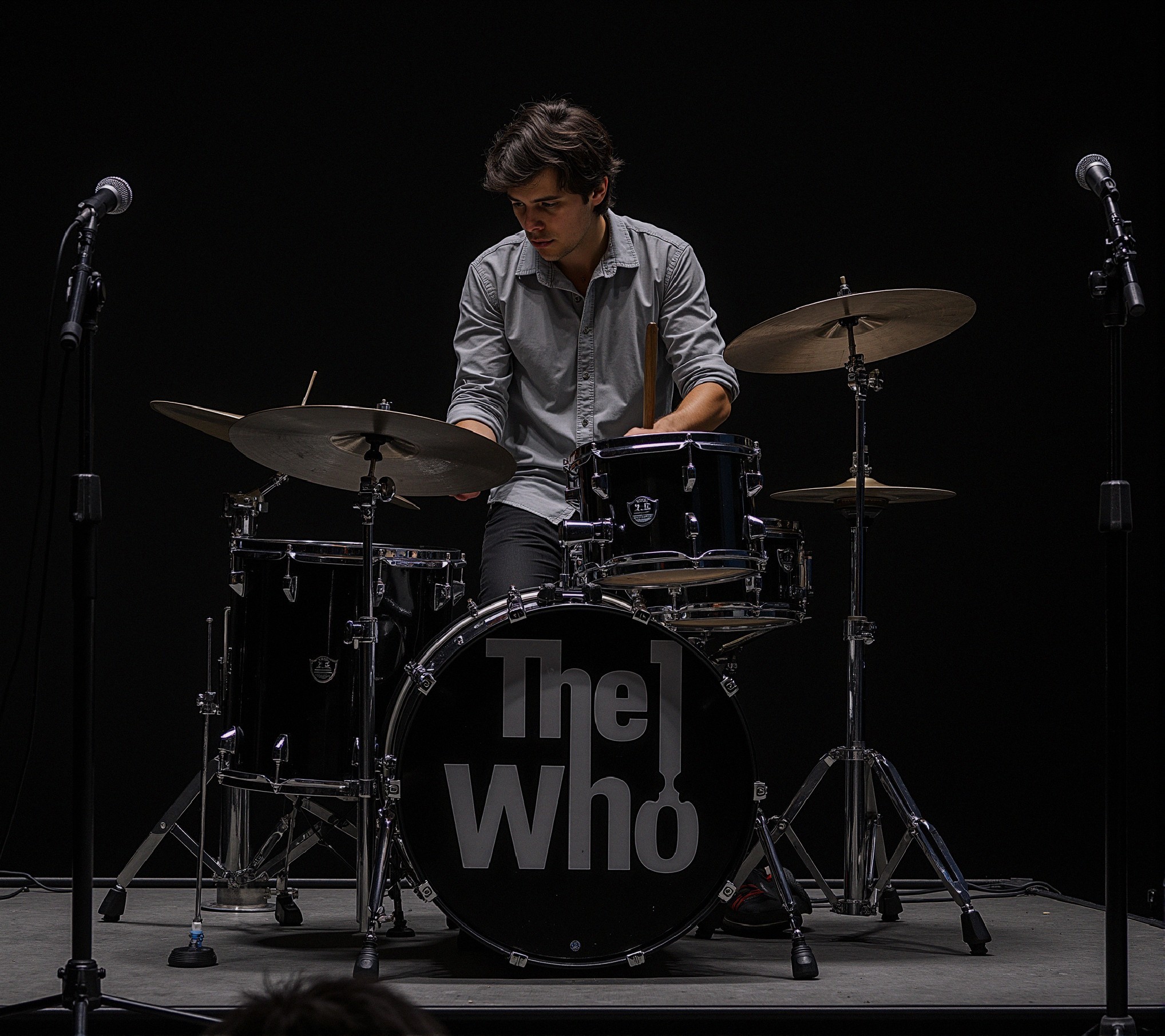Young drummer with classic black drum set on stage