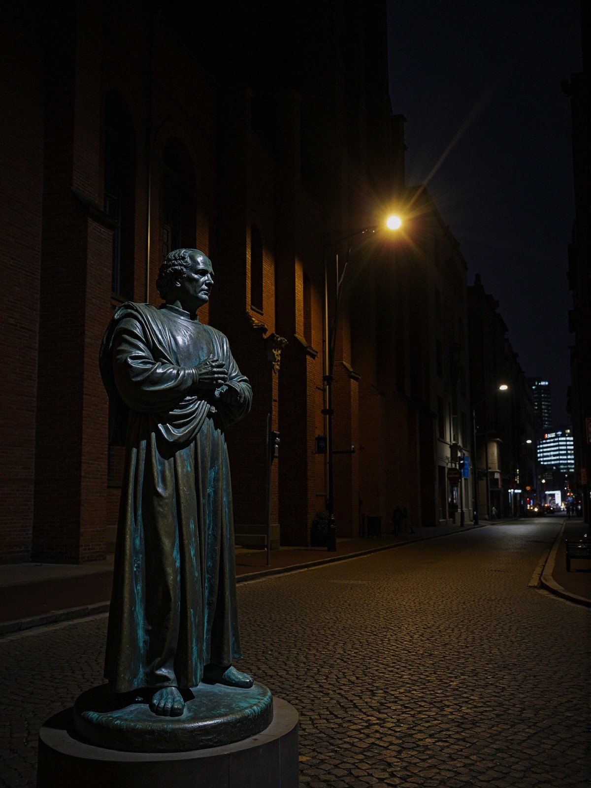 Bronze Statue of Historical Figure in Dimly Lit Street