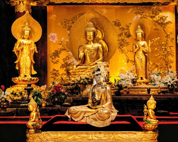 Buddhist Altar with Golden Statues and Floral Arrangements