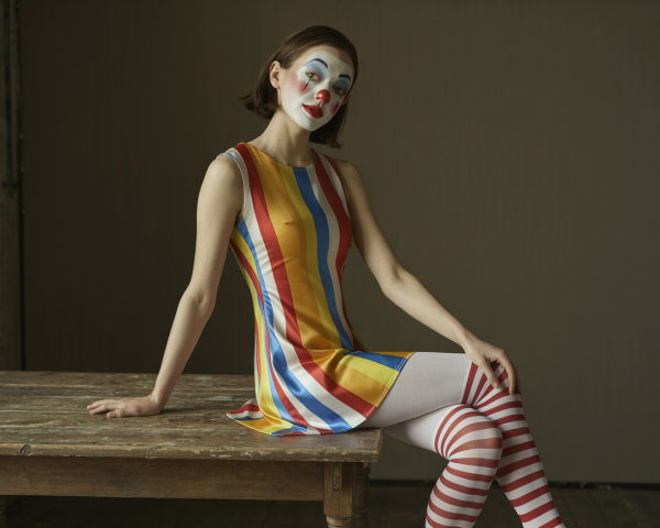 Clown Makeup Model on Rustic Table with Colorful Dress