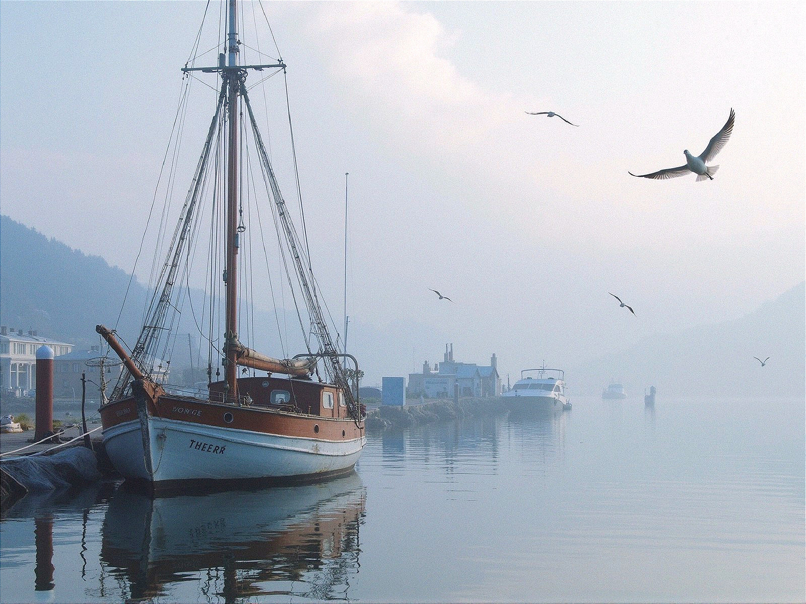 Serene Harbor Scene with Sailboat and Mist
