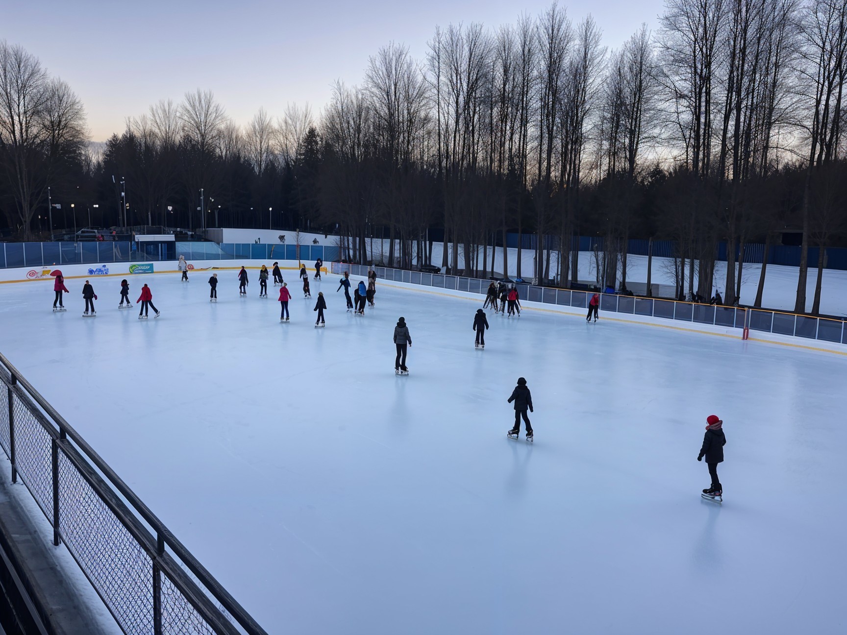 Outdoor Ice Skating Rink with Skaters at Dusk