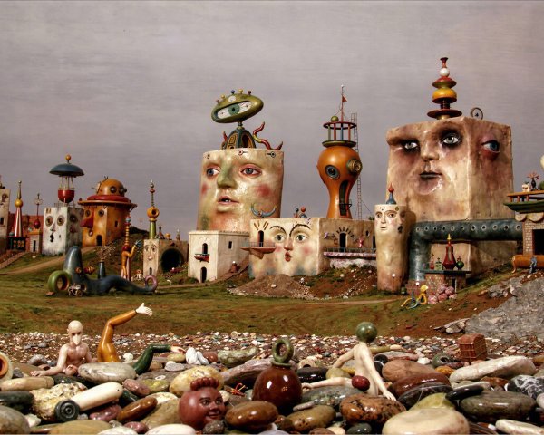 Surreal dreamscape with grotesque faces and claymation city