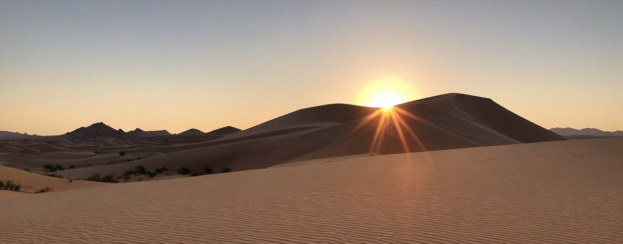 Desert Landscape at Sunrise with Golden Sky and Dunes