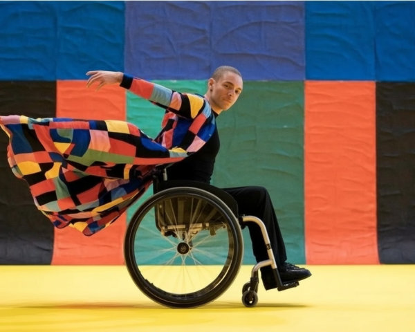 Dancer in Wheelchair Performs on Vibrant Yellow Stage