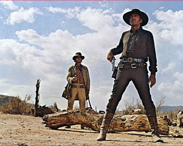 Cowboys in Barren Landscape Under Partly Cloudy Sky