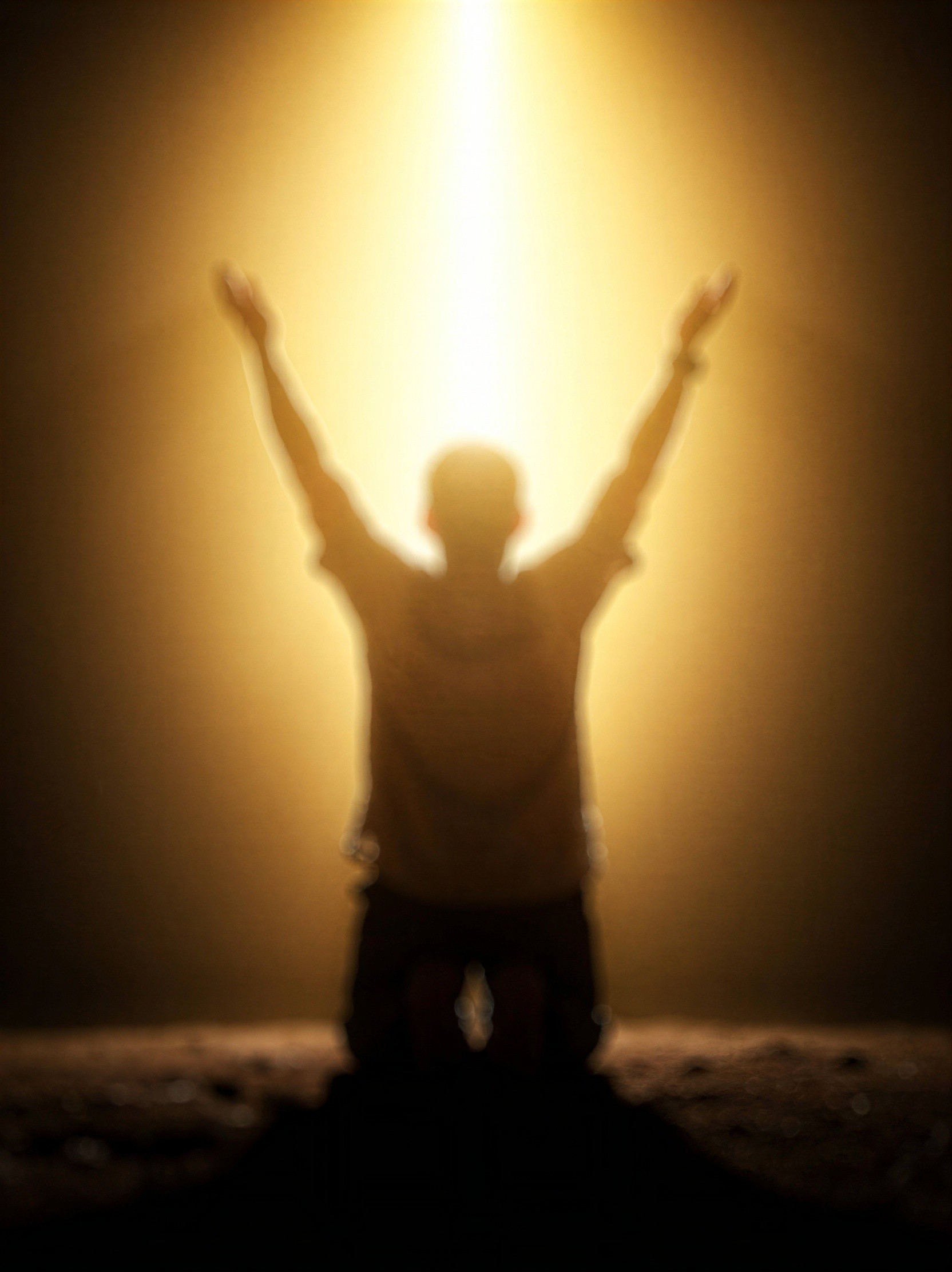 Blurry Silhouette of Kneeling Figure on Rocky Ground
