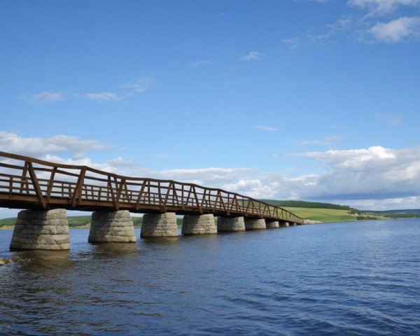 Wooden bridge on stilts over a blue lake with reflections
