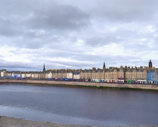 Panoramic View of River and Ornate Building with Cars