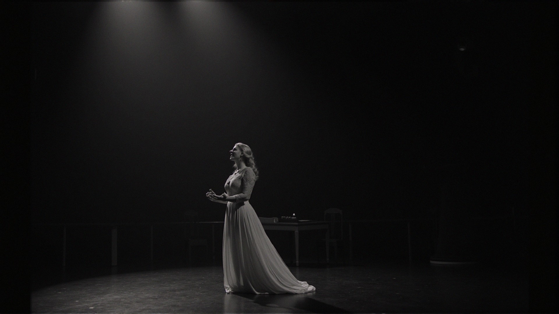 Solitary Figure in Flowing Gown Under Spotlight