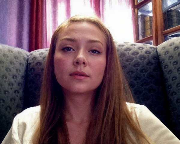 Young woman in upholstered chair with natural light