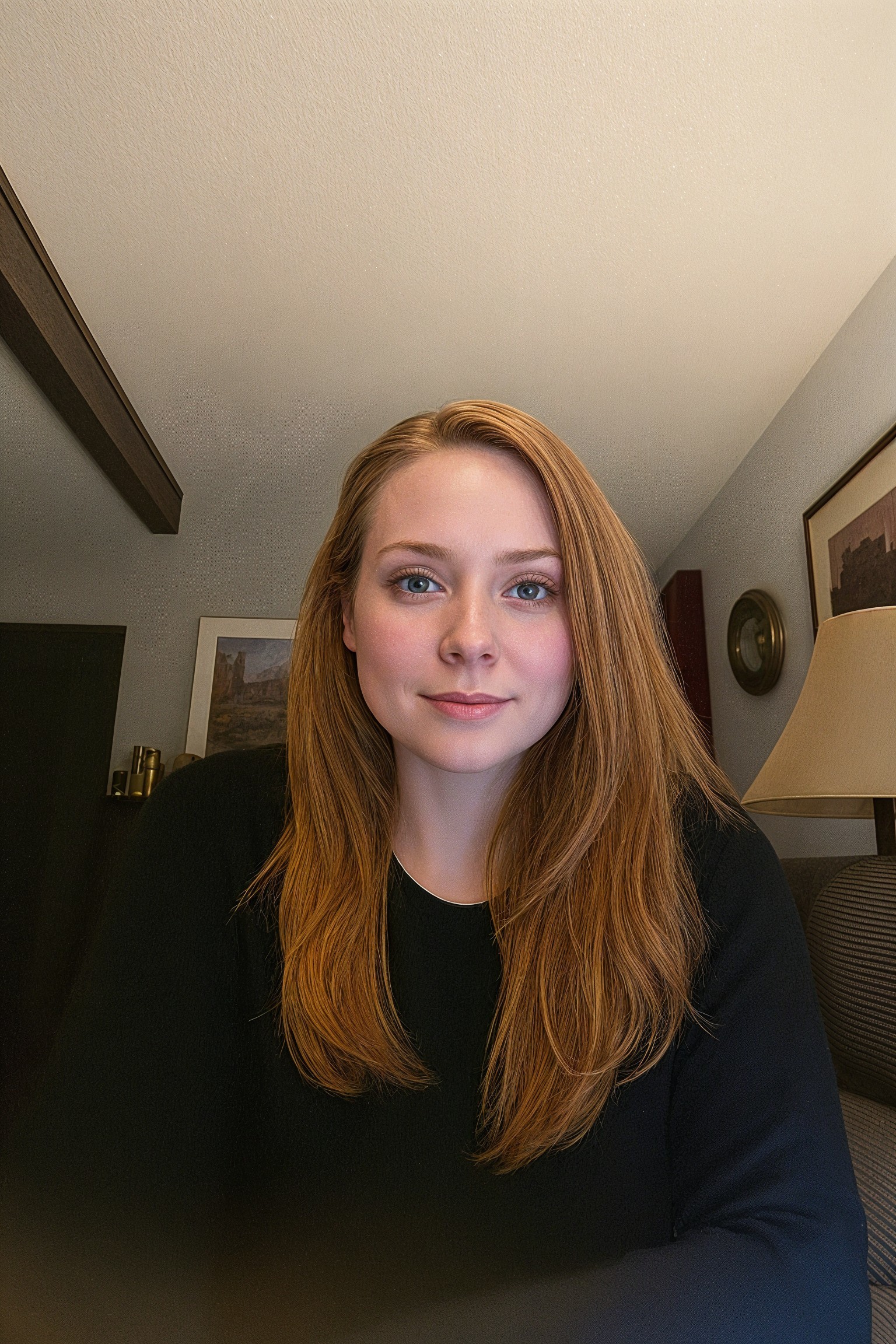 Young woman with reddish-brown hair in cozy room