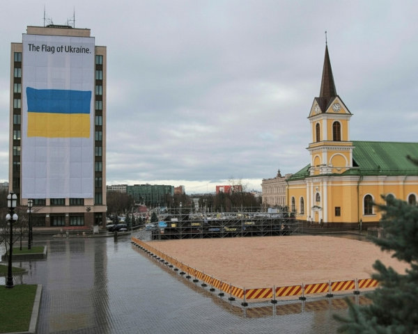 City square with Ukrainian flag and historic church