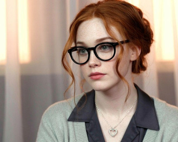 Portrait of a young woman with red hair and glasses