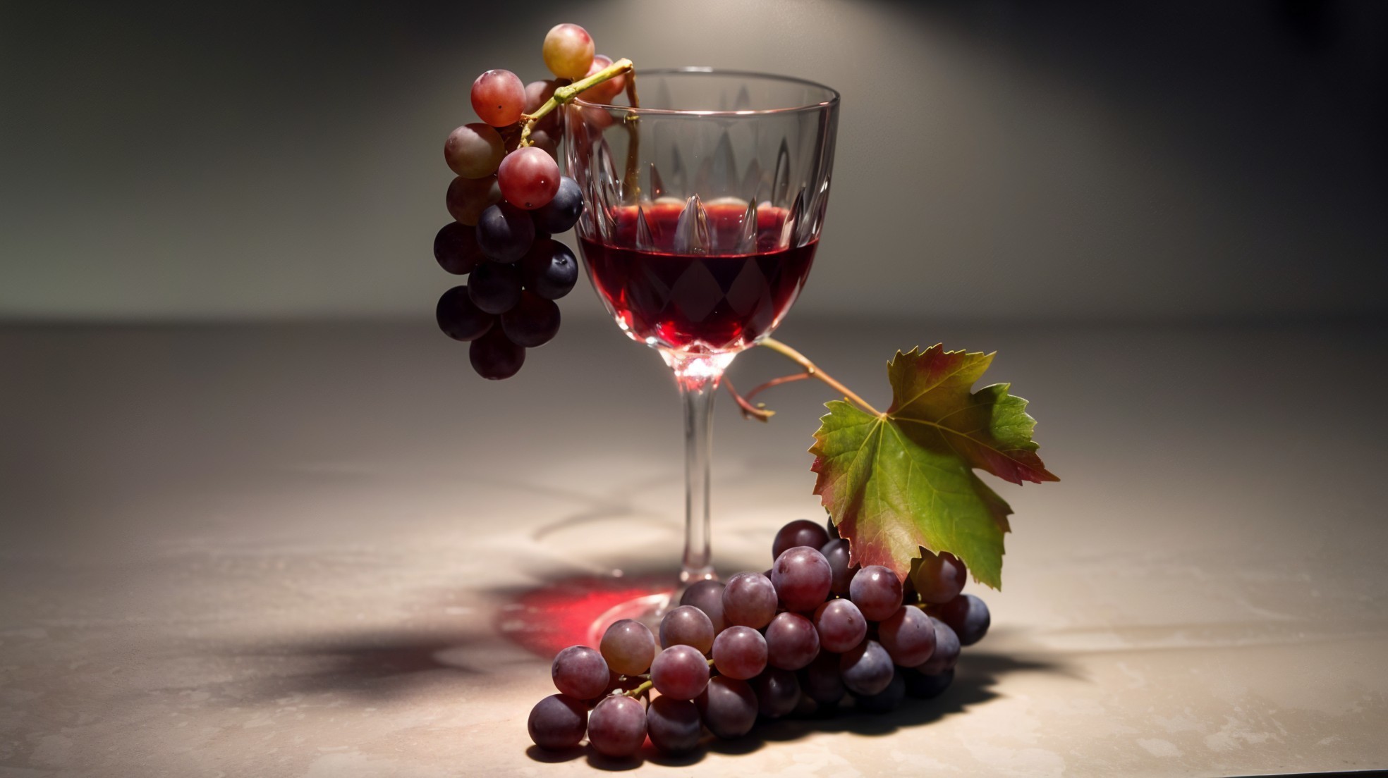 Crystal Glass of Red Wine with Grapes and Green Leaf