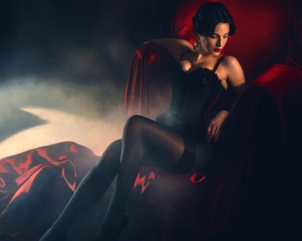 Glamorous woman in plush red chair with soft lighting
