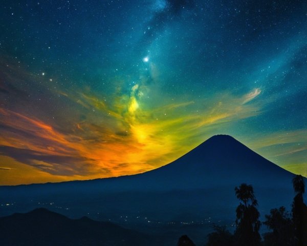 Night Sky Over Majestic Volcano with Colorful Clouds