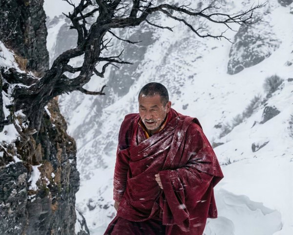 Monk Walking in Snowstorm on Mountain Path with Temple