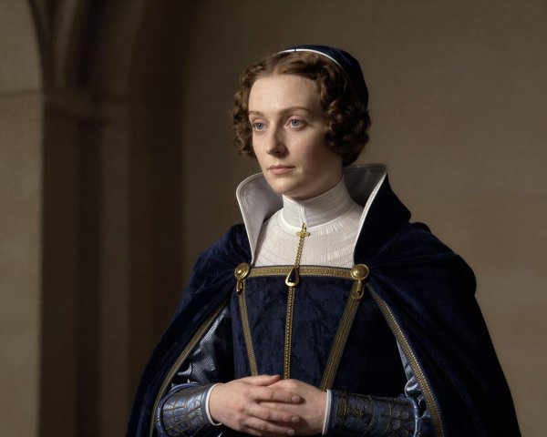 Auburn-haired woman in ornate blue and gold attire