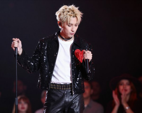 Male vocalist in sequined jacket on dimly lit stage