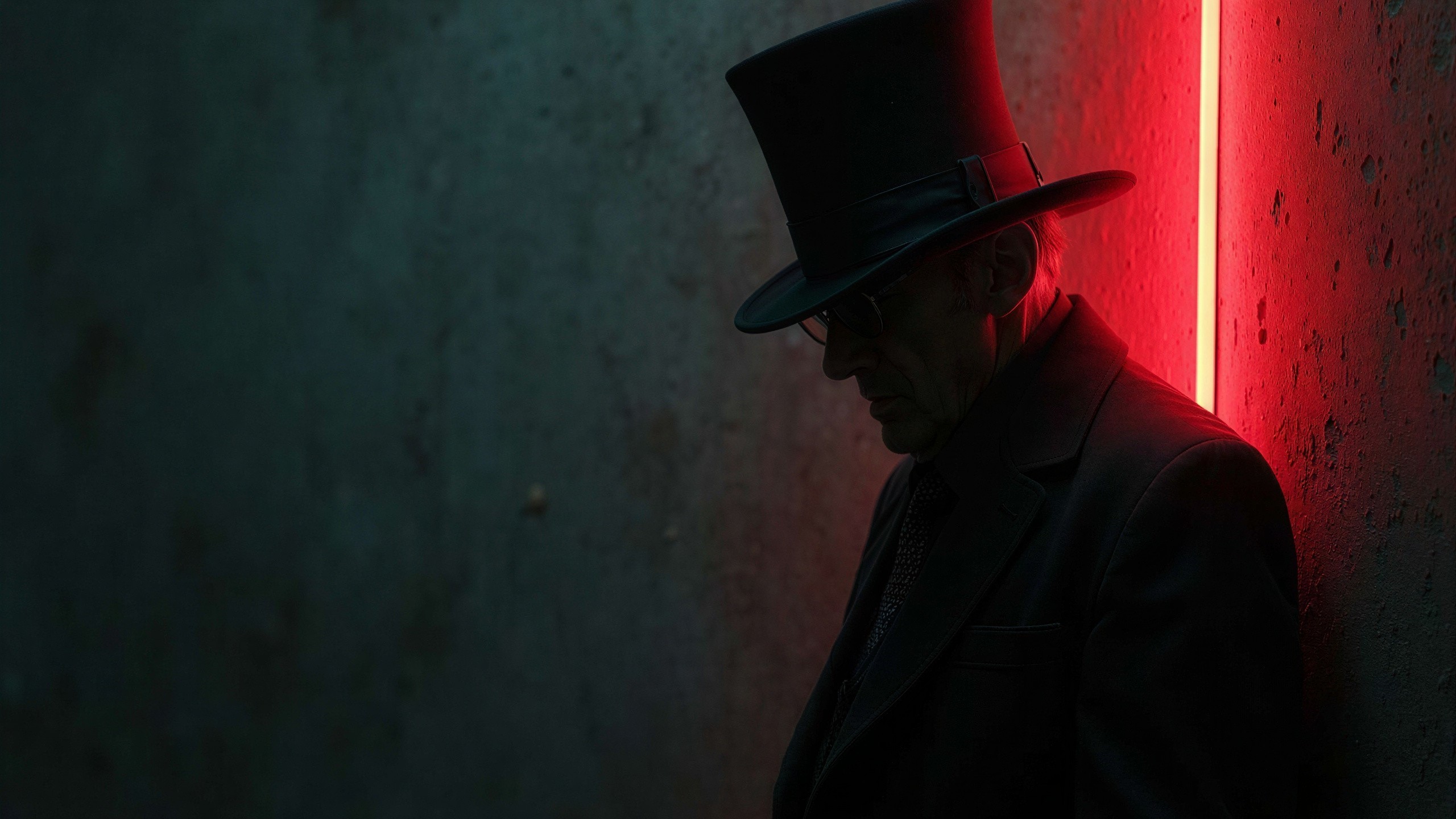 Older man in top hat by textured teal-grey wall