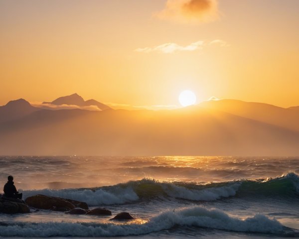 Coastal Sunset with Mountains and Tranquil Waves