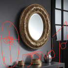 Golden-framed mirror with geometric decor and vases on sleek surface