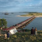 Historical military camp near waterfront with soldiers