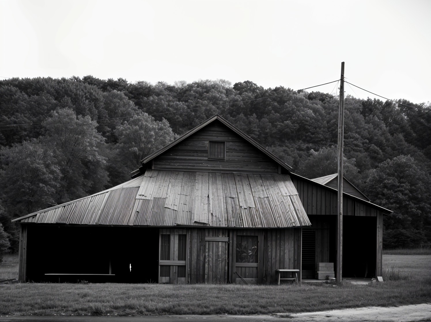 Weathered barn in rural landscape captured in black and white