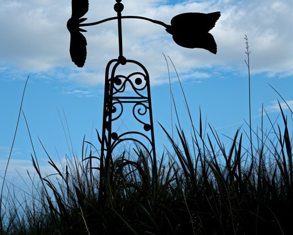 Decorative Owl Weather Vane Against Blue Sky