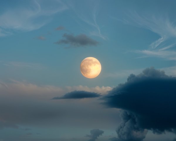 Full Moon Illuminates Serene Sky with Wispy Clouds