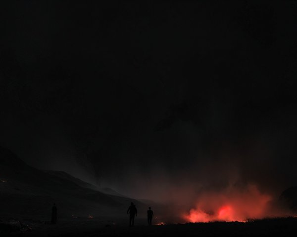 Silhouetted Figures in a Volcanic Landscape at Night