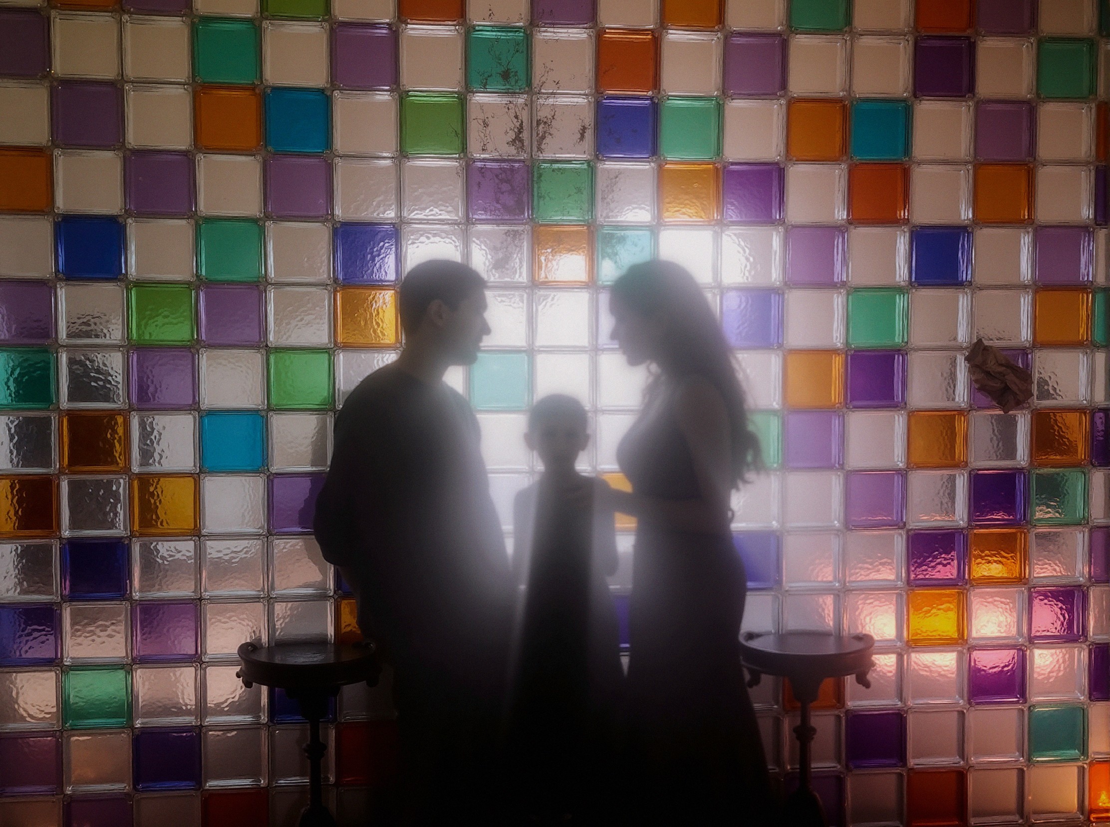 Silhouetted Family Against Colorful Glass Block Wall