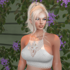 Young woman in lacy top among greenery and flowers