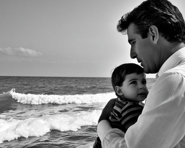 Tender Father-Son Moment by the Ocean in Black and White