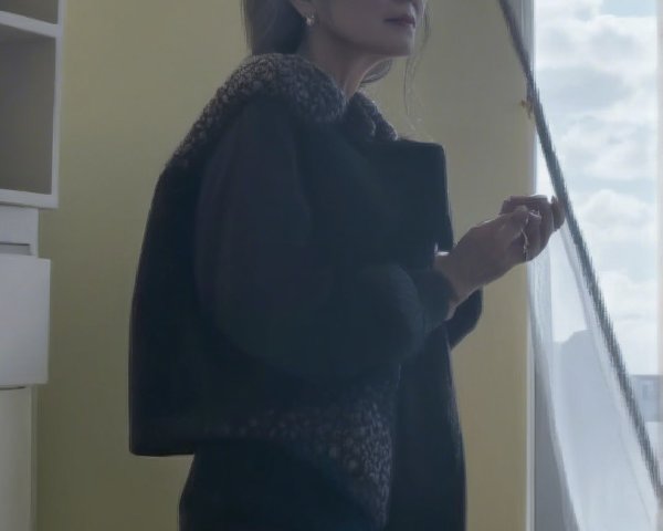 Woman by Window in Elegant Dark Jacket and Soft Light