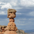 Solitary Rock Formation with Trees in Snowy Mountain Landscape