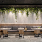 Stylish restaurant interior with green velvet furniture and hanging plants