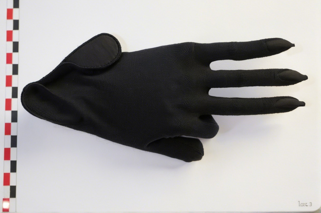 Black Glove with Fingertip Designs on White Surface