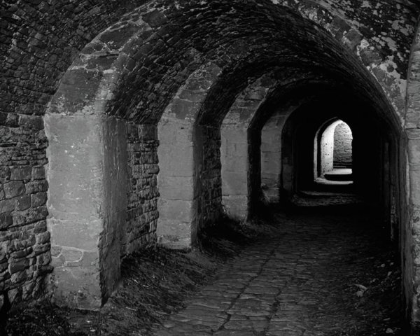Dimly Lit Stone Corridor with Aged Textured Walls