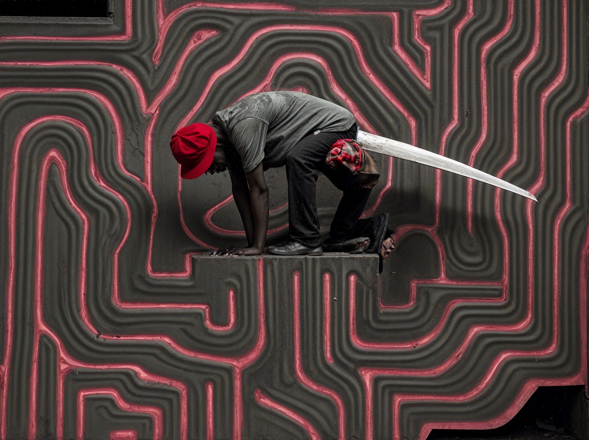 Crouching Figure in Red Hat Against Vibrant Background
