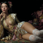 Elegant model in golden outfit against dark backdrop